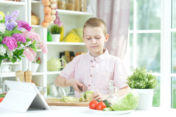Cute little boy making dinner