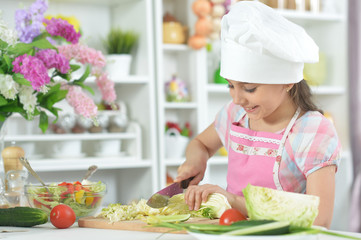 Cute little girl making dinner