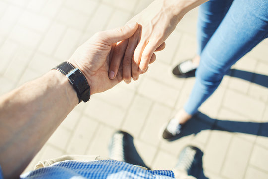 top view of male and female hands together. walking couple