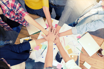 Asian smart freelancer group in casual suit join their hands together for agree to start creative project in modern office. Business and Technology concept