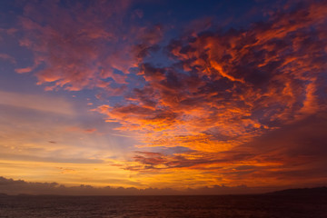 Fototapeta na wymiar summer sunset colorful sky with dramatic purple red and yellow clouds over picturesque water landscape. Bali, Indonesia.