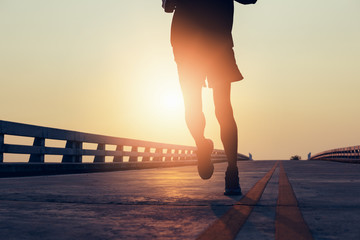 The man with runner on the street be running for exercise.