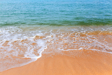 yellow sandy coastline with azure foamy ocean waves on a bright Sunny day. Bali, Indonesia.