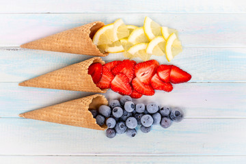 waffle cups with strawberries, blueberries and lemon. berry background.