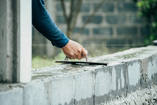 Blue Collar Workers Working In Factory,Worker Builds A Brick Wall.