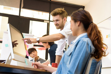 Obraz premium Smart handsome european man business officer explaining internal meeting to his project team in modern office. They are the multi ethnic business person group in casual suit. 