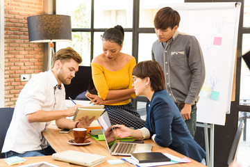 Smart handsome european man business officer explaining internal meeting to his project team in modern office. They are the multi ethnic business person group in casual suit.