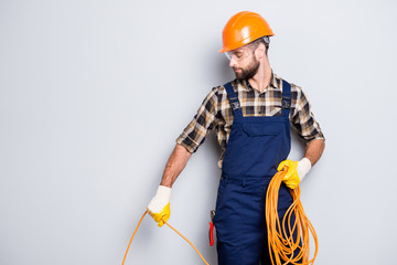 Half face portrait of busy stylish electrician with stubble in overall, shirt, hardhat installing,...