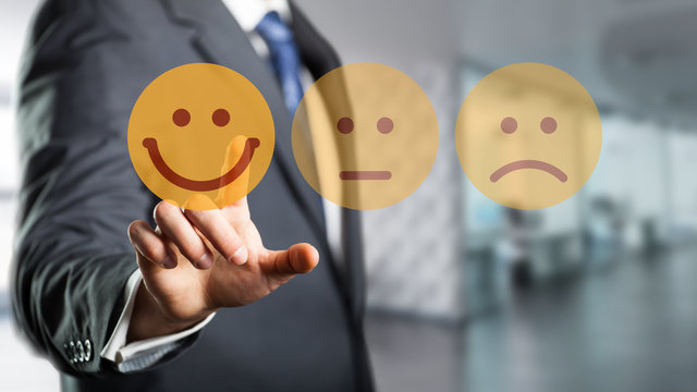 Geschäftsmann wählt lächelnden Smiley vor Bürohintergrund