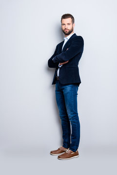 Full size body portrait of elegant trendy teacher with stubble having his arms crossed looking at camera isolated on grey background, wearing jacket, jeans, shirt
