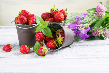 Strawberry in a bucket and flowers