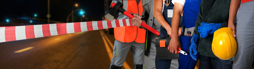 Workers on a road construction, repairing the road in the night city