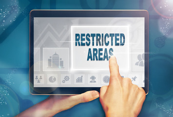 A hand selecting a Restricted Areas business concept on a computer tablet screen with a colorful background.