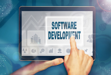 A hand selecting a Software Development business concept on a computer tablet screen with a colorful background.