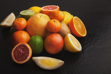 Heap of citruses on black background, closeup