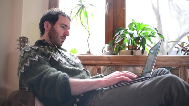 A Man use Laptop working outsource at Home near the Window - Day