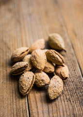 Roasted almonds in shell on the rustic background. Selective focus.