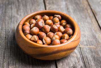 Hazelnuts in shell on the rustic background. Selective focus.