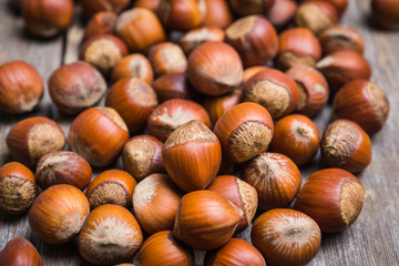 Hazelnuts in shell on the rustic background. Selective focus.