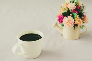 White coffee cup on the bed in morning.