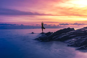 Foto op Canvas Silhouet vrouw yoga op het strand © Success Media
