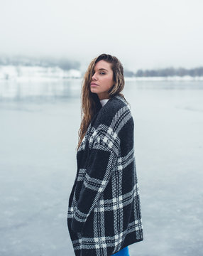 Young lady staying on frozen lake