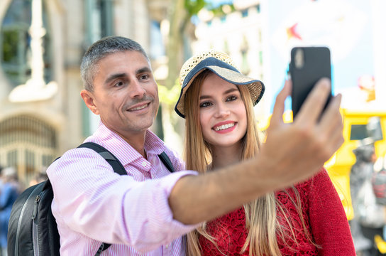 Happy couple making selfies during city visit. Tourism and holiday concept