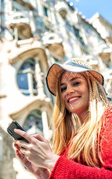 Happy beautiful blonde girl using smartphone visiting city. Tourism and holiday concept