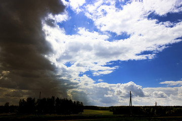 Fototapeta na wymiar Near the village. Storm. The sky meets a thunderstorm. The sun shines through the clouds