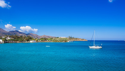 Obraz premium Small natural harbor with anchored sailing boat, Agios Nikolaos, Crete, Greece.