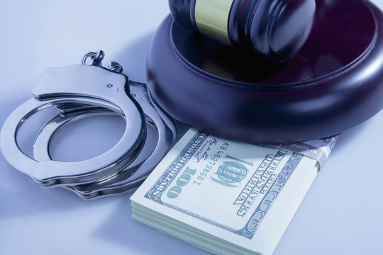 Dollar banknotes, handcuffs and judge's gavel as symbol of corruption in the judicial system