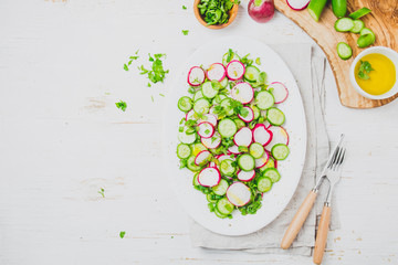 Obraz na płótnie Canvas Fresh radish cucumber salad, white background. Top view