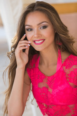 Fototapeta premium Portrait beautiful brunette with long hair on the beach. Natural woman beauty. Toned in warm colors.