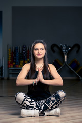 Obraz na płótnie Canvas beautiful brunette doing yoga in the gym, simple asanas