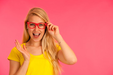 Portrait of a funky young woman in yellow t shirt over pink background