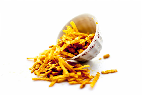Popular Indian & Asian snack Farali chevdo or Faralu chivdo or potato fries with peanut in a glass bowl isolated on white.
