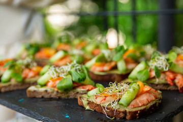 Appetizer canape with shrimp and cucumber on plate on table close up