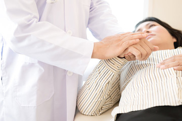 Doctor with patient. Routine health check and holding hands. Male medical doctor with middle age chinese woman.