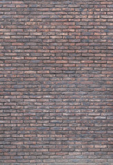 Vertical dark red brick wall background, wallpaper. Red bricks pattern, texture.