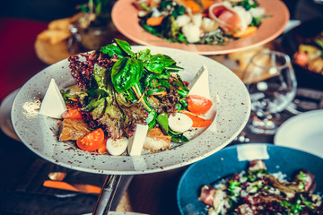 many different dishes in Restaurant, white plate on the Table with side dish,