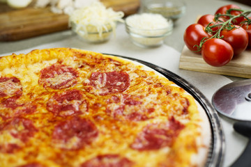 Freshly baked italian pizza on a metal mesh pan