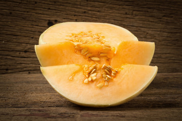 melon (sunlady) slice. half. on old wood. morning