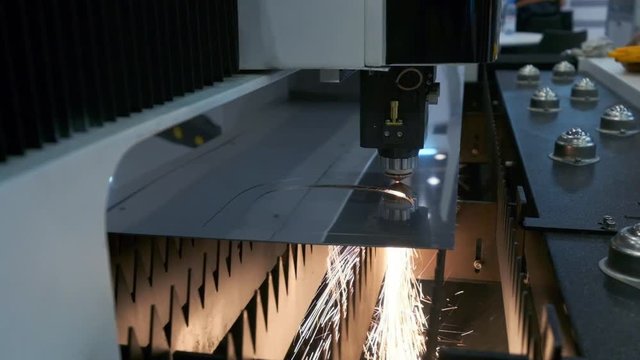 Industrial robotic laser cutter cuts metal parts with great precision.