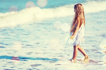 Beautiful girl in white dress on beach