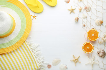 Different seashells with fruit and clothes on wooden table