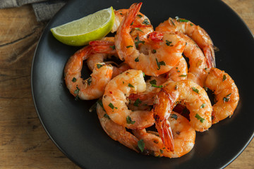 fried roasted shrimps in plate with lemon greens parsley garlic