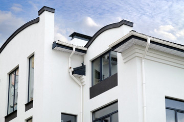 Newly installed construction frame house rain gutter system on the roof top
