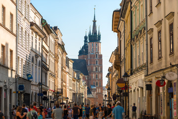 Fototapeta na wymiar a crowd of tourists on Florian street, view of the Mariinsky church in the center of Krakow, Poland
