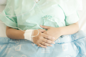 Young patient alone in bed. Sleeping in hospital bed. Body shot. Young beautiful chinese woman.