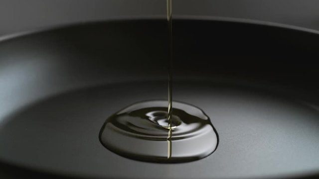 Pouring oil over fry pan. Shot with high speed camera, phantom flex 4K. Slow Motion.